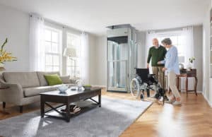 Couple with wheelchair near home lift in living room
