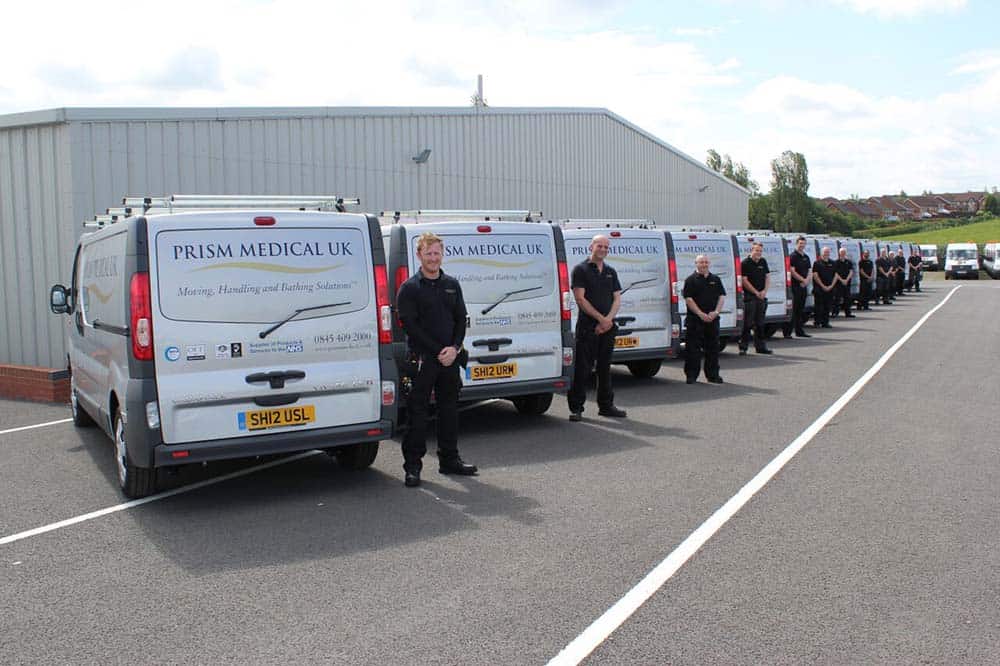 Prism Medical UK team standing outside vans