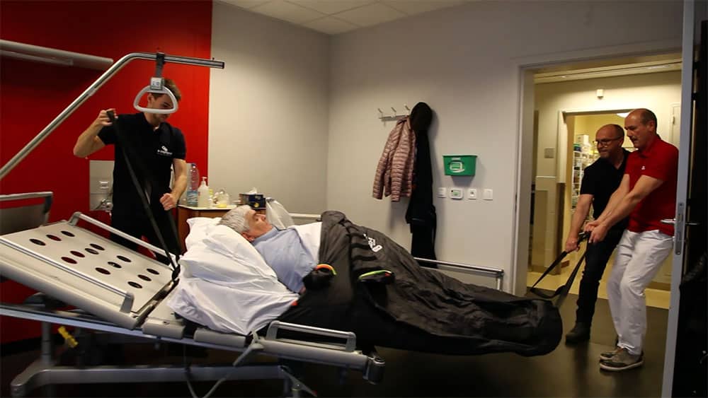 S-CAPEPOD in use, with bariatric patient carried by three healthcare professionals