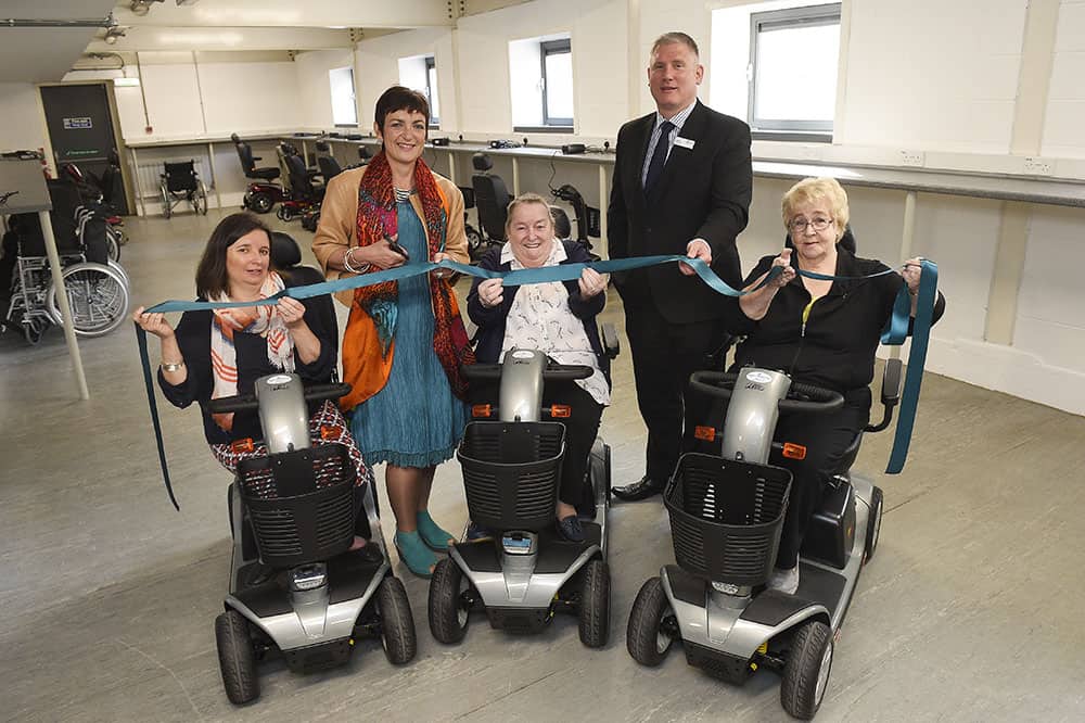 The Centre opens their Livingston Mobility Service where manual wheelchairs and scooters are available to loan for visitors to The Centre.  Pictured cutting the ribbon is Angela Constance with Patrick Robbertze (Director, The Centre) and visitors to The Centre who will be making use of the scooters (left to right) Morven Pritchard, Mary Couper and Carol Seivewright