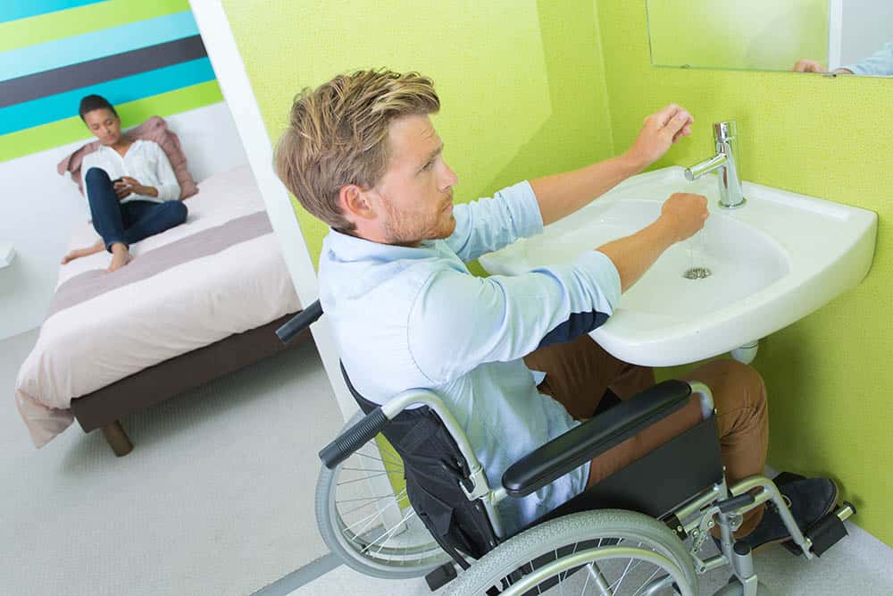 Disabled man using bathroom in accessible home