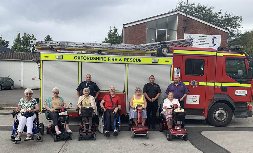 Pride Mobility scooter user group in front of fire truck in Bicester with Shire Mobility