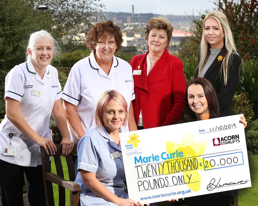 Acorn Stairlifts celebrate after raising £20,000 for Marie Curie outside