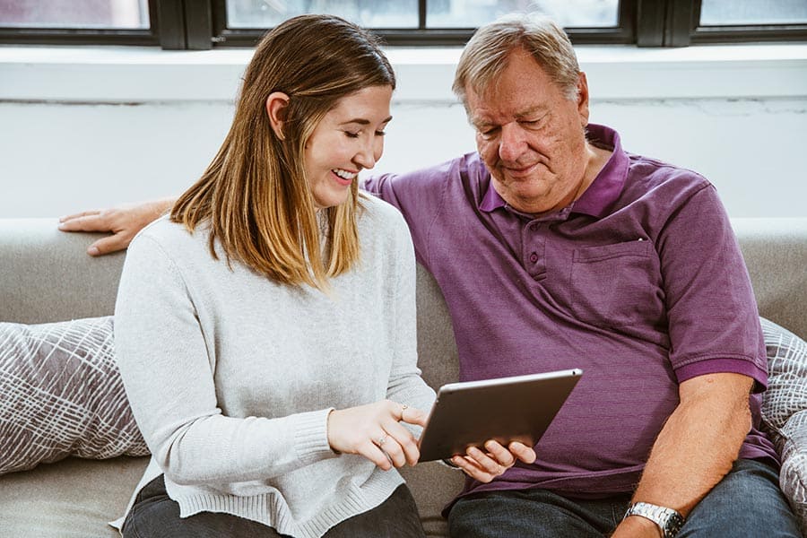 young woman and older man using technology