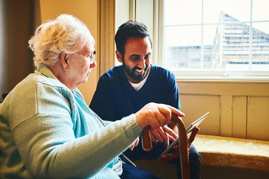 Older woman and care worker using a tablet image