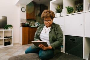 Lady using tablet in living room. Image by Centre for Ageing Better.