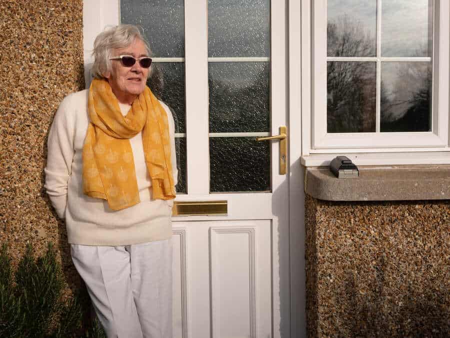 Elderly lady outside house