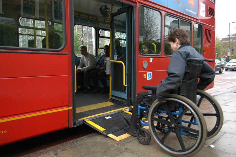 Wheelchair user boards bus with a ramp